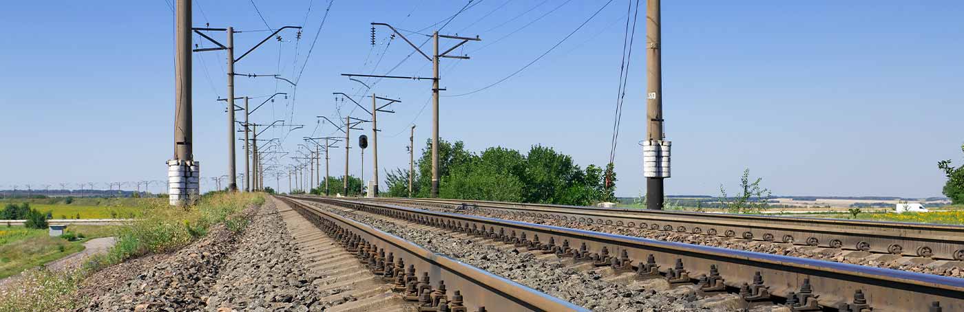 A picture of railroad tracks in a rural area with telephone poles lining it